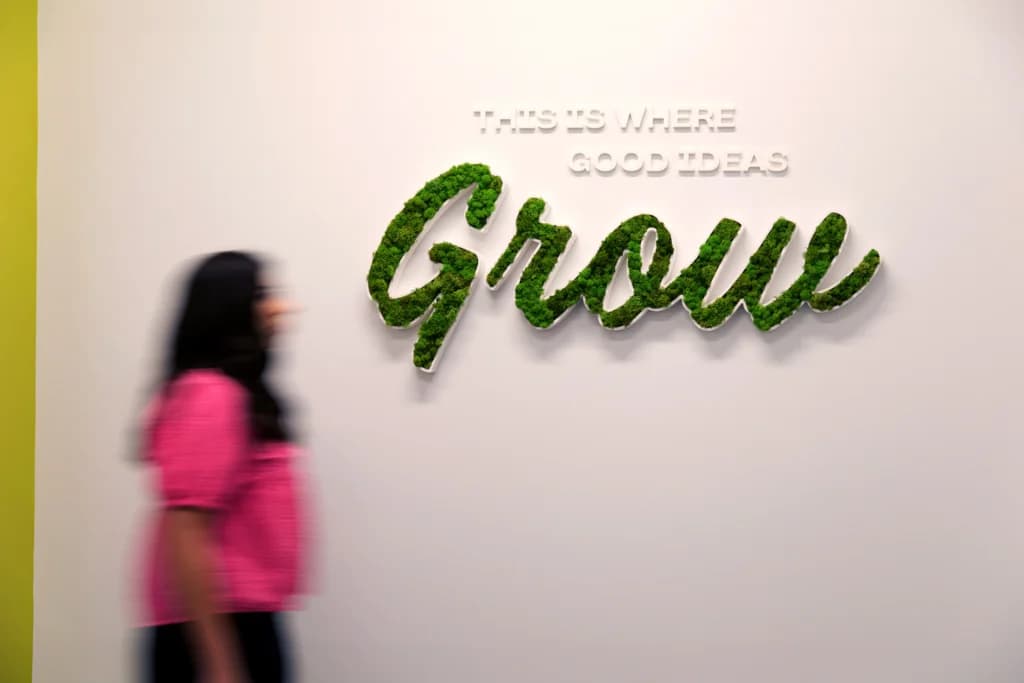 a woman standing in front of a sign that says grow