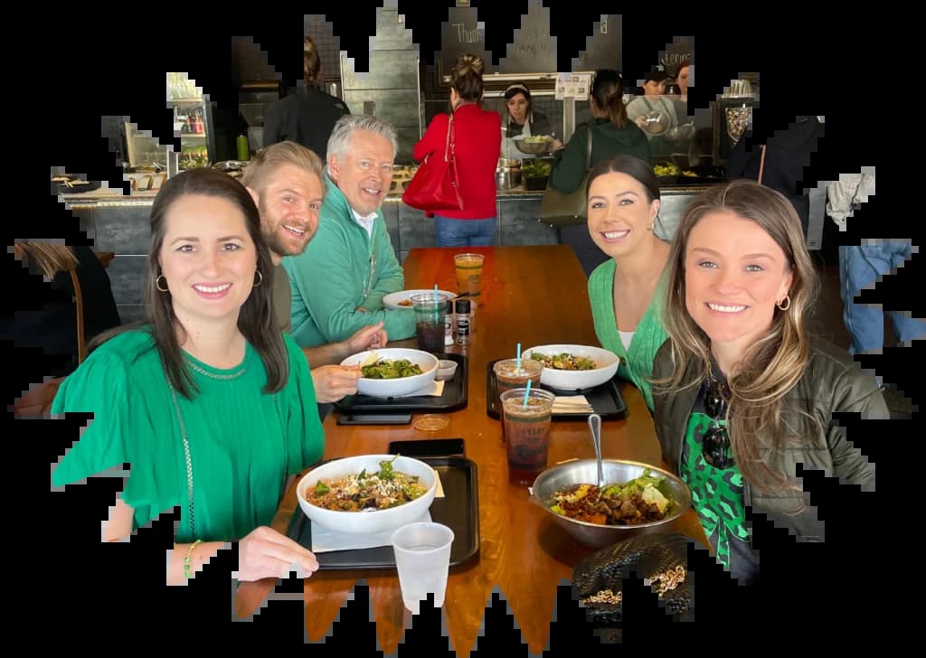 A group of people sitting around a table enjoying a meal together