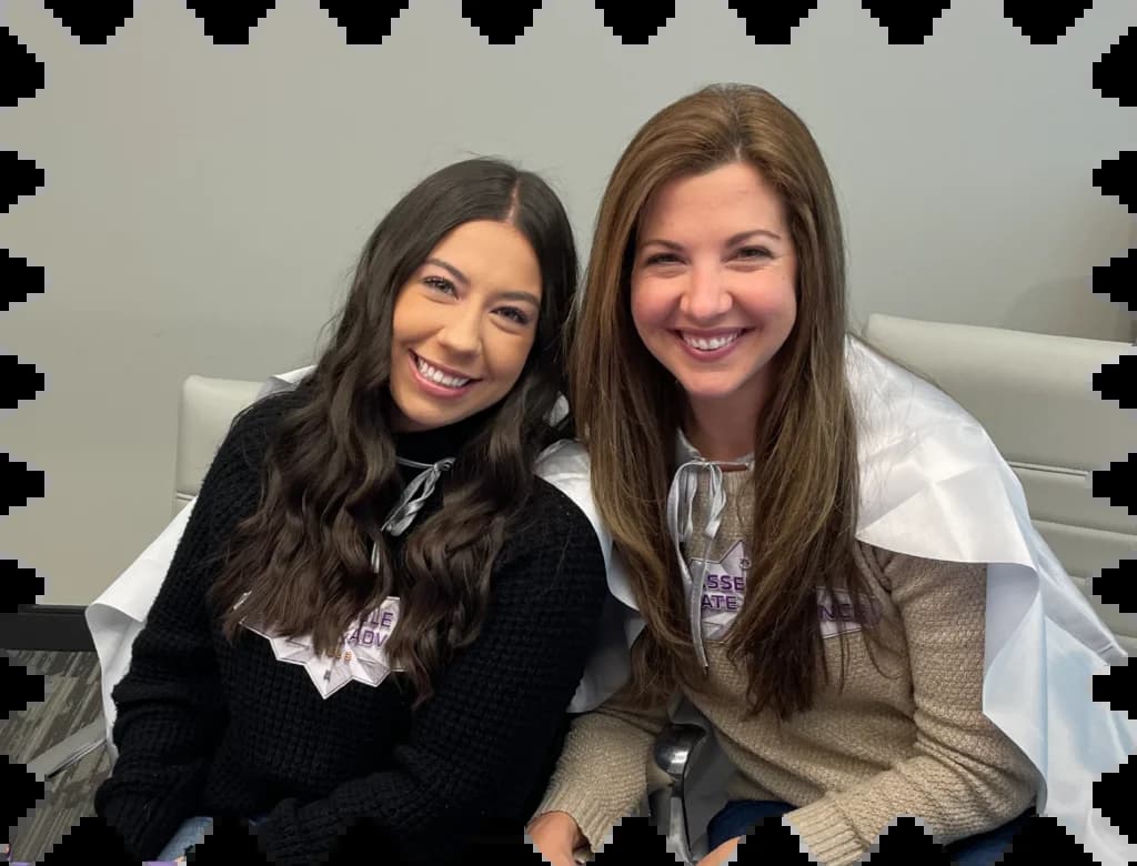 A couple of women sitting next to each other on a bed