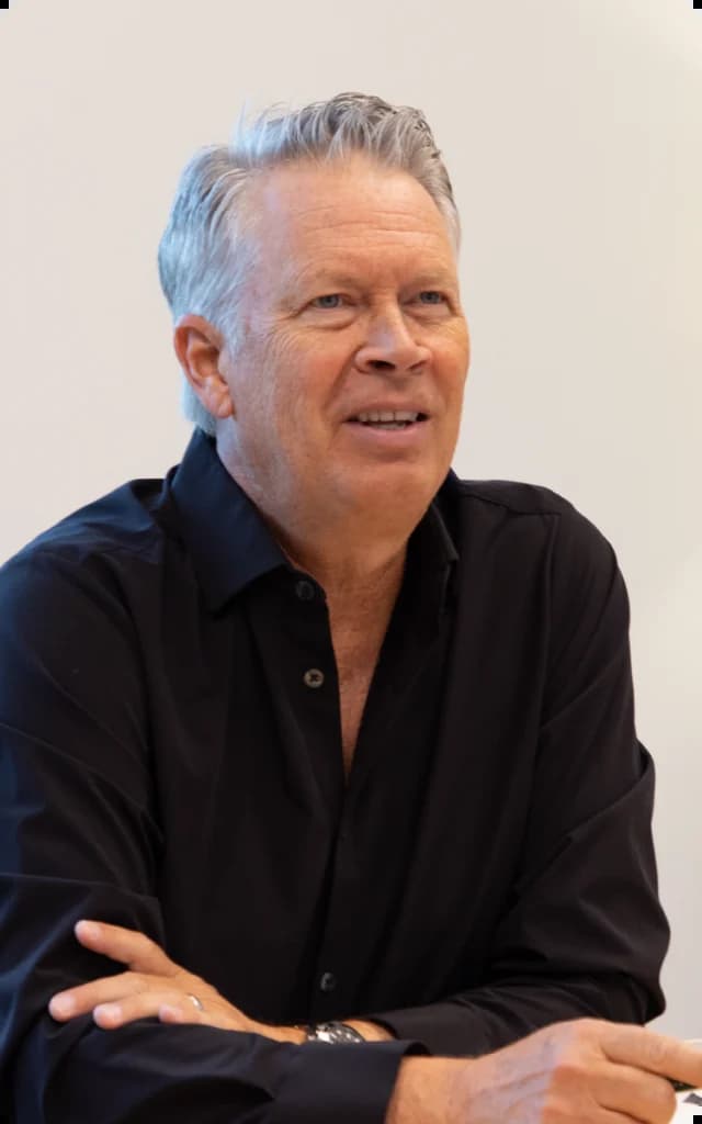 A man sitting at a table with his arms crossed