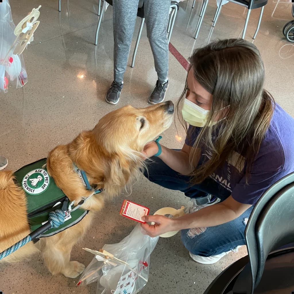 a woman wearing a face mask petting a dog