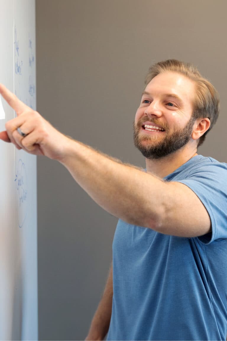 a man pointing at something on a wall