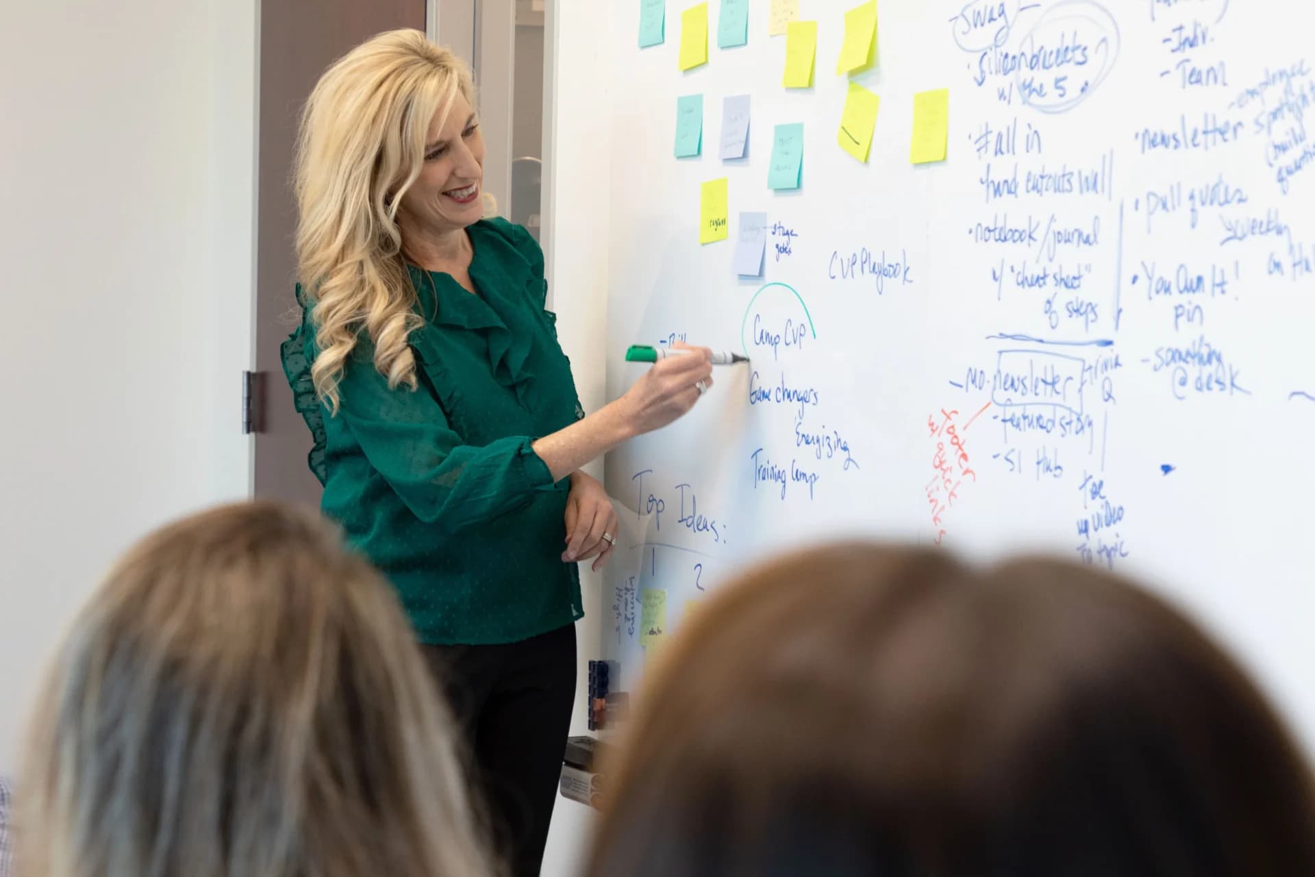 a woman standing in front of a whiteboard with notes on it