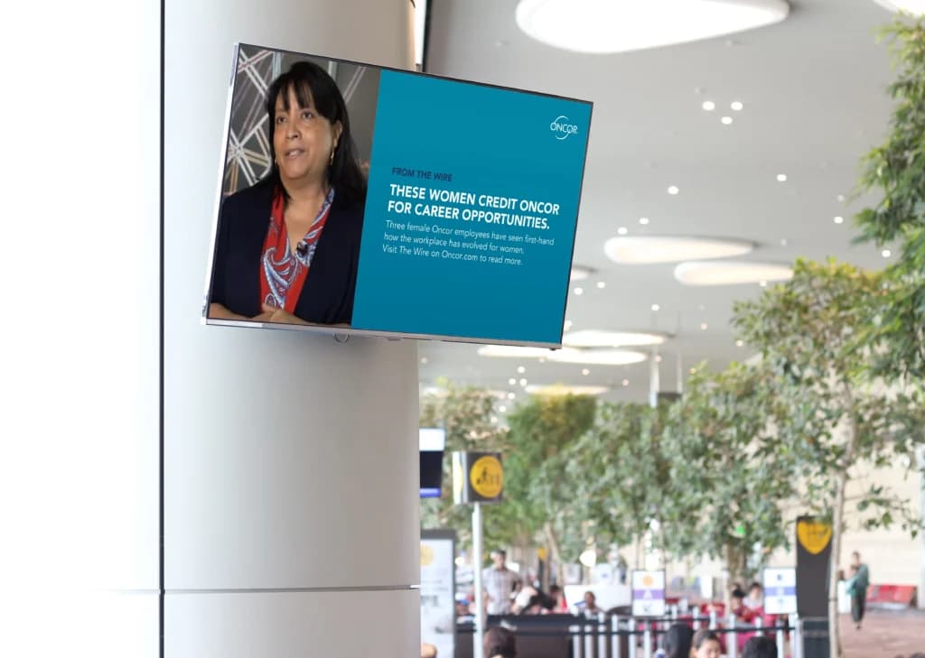 a woman standing in front of a sign in an airport