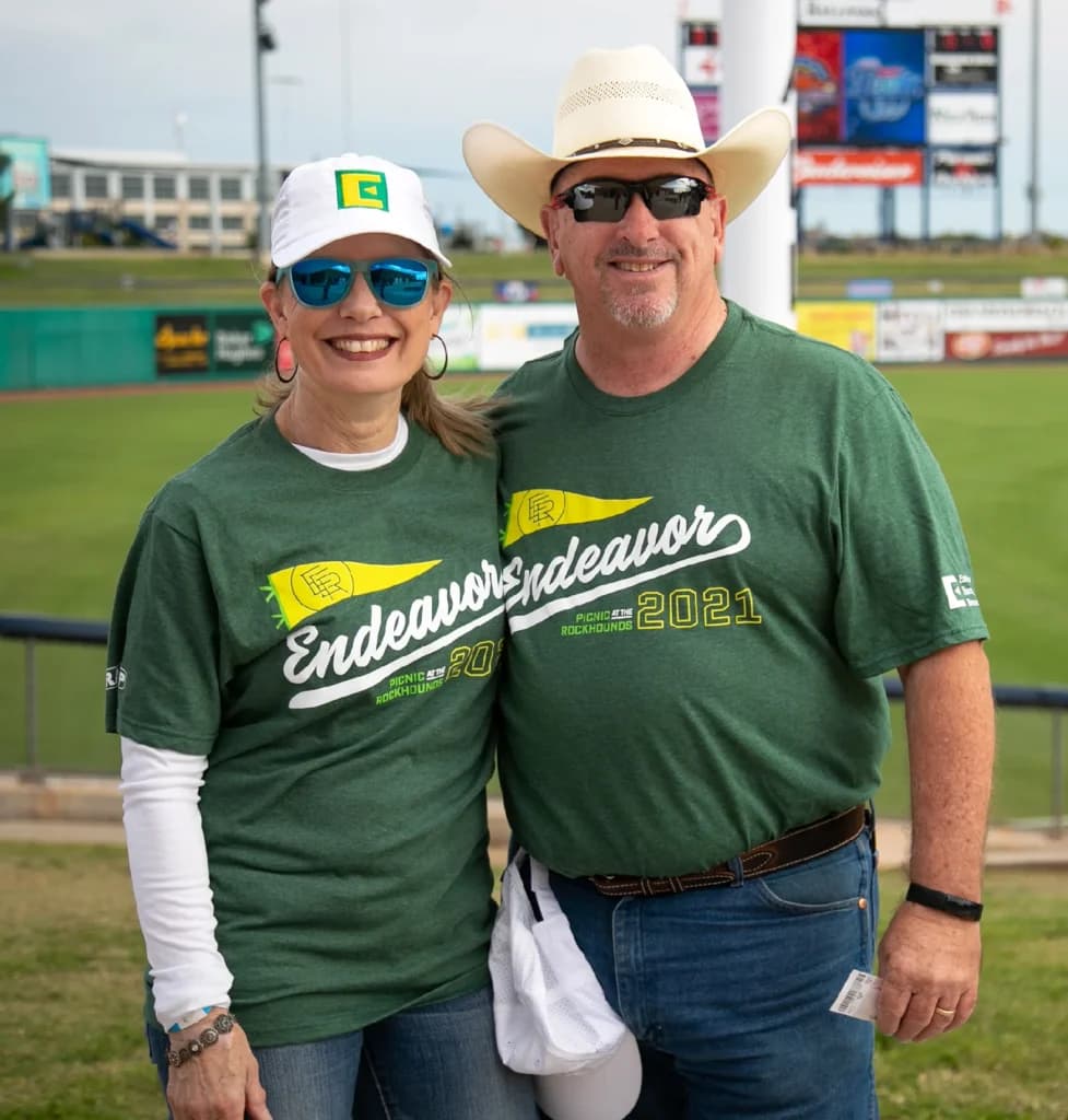a man and a woman standing next to each other on a baseball field