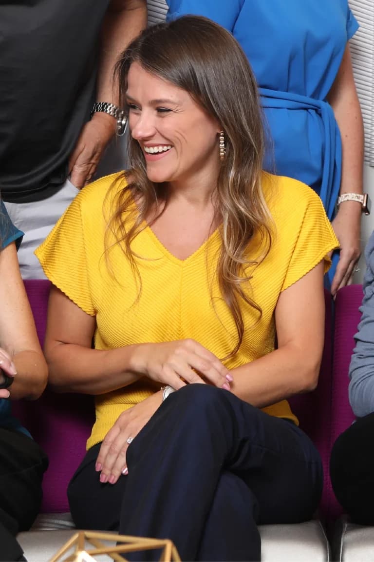 a woman in a yellow shirt sitting on a purple couch